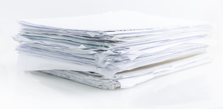 Large pile of waste paper isolated on white, ready for recycling.