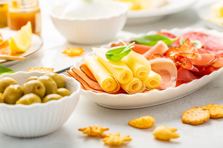 Appetizers with differents antipasti, charcuterie, snacks, meat platter with cheese and spicy olives, salmon carpaccio and tomato saladの写真素材