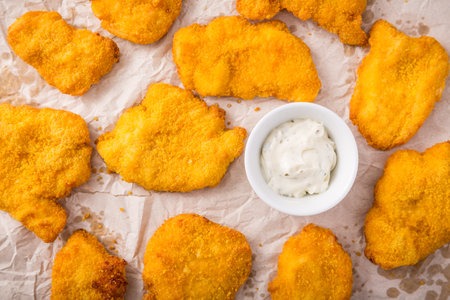 Small chicken schnitzel on baking sheet with herb mayonnaiseの写真素材