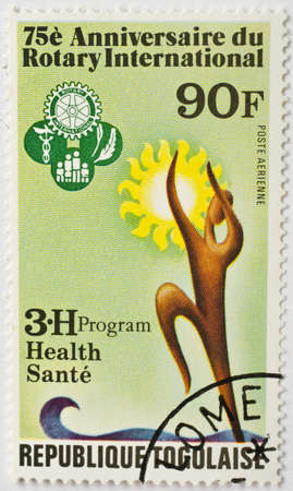  TOGO - CIRCA 1980  a stamp from Togo with Lome postmark shows image commemorating the 75th anniversary of Rotary International  the Rotary Club , the international service club, circa 1980 のeditorial素材