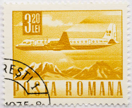 ROMANIA - CIRCA 1975  A stamp from Romania shows image of an airplane flying over mountains, circa 1975 の写真素材