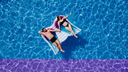 Above vertical view of people young couple taking hands with love and having fun on the blue clear...