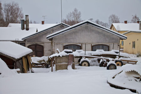 Old factory building in the snow, with old scrap lying aroundの写真素材