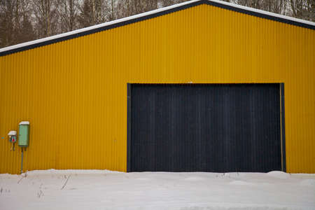 Yellow metal building with black rectangular doorの写真素材