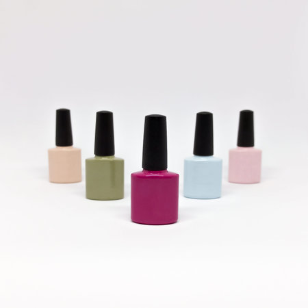 Nail polishes isolated. Colorful nail polishes and bottles on white background