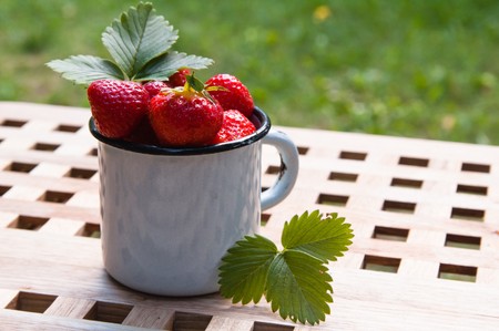 Strawberry in a mug on a tableの写真素材