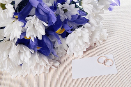 The invitation to wedding. A bunch of flowers and wedding ringsの写真素材