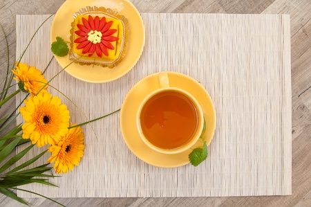 tea with cake and gerberas flowersの写真素材
