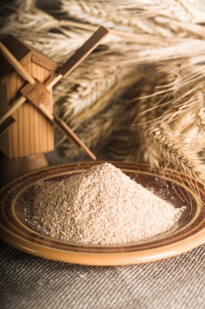 Wholemeal flour and wheat on cloth sack, close-upの写真素材