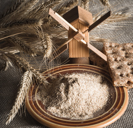 Wholemeal flour and wheat on cloth sack, close-up