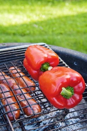 Red sweet pepper and sausages on a grillの写真素材
