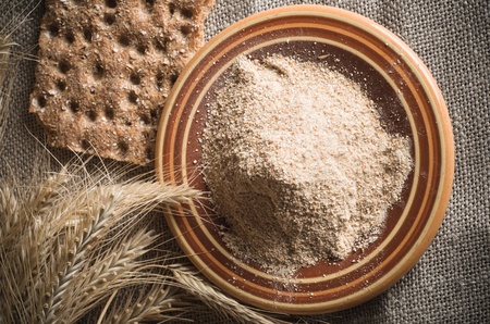 Wholemeal flour and wheat on cloth sack, close-upの写真素材