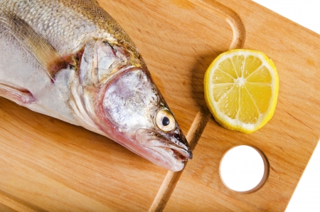 Pike perch on a wooden kitchen board, it is isolated on whiteの写真素材