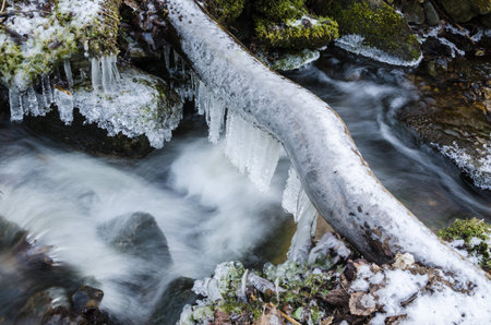 Frozen icicles on water flowの写真素材