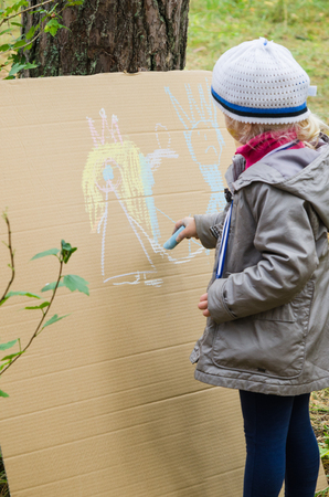 Little girl drawing with crayons on cardboardの写真素材
