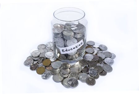 Saving idr coins in the glass bottle jar for education on white backgroundの写真素材