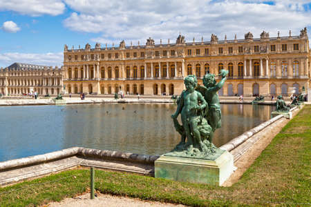 Versailles, France - August 20 2017: Bronze statue of three cherubs placed on the edge of a basin of the Bassin du Midi in the gardens of Versailles, in front of the west facade of the Palace of Versailles.のeditorial素材