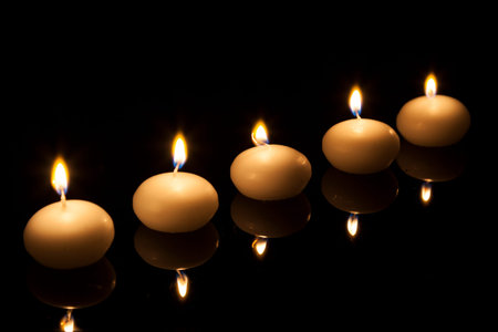Row of round candles lite in the dark.の写真素材
