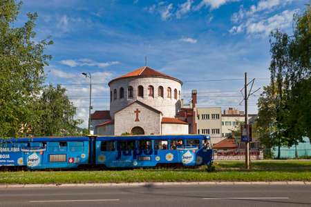 Sarajevo, Bosnia and Herzegovina - May 25 2019: A blue tramway passing in front of the Serbian Orthodox Church of the Holy Transfiguration in Novo Sarajevo.のeditorial素材