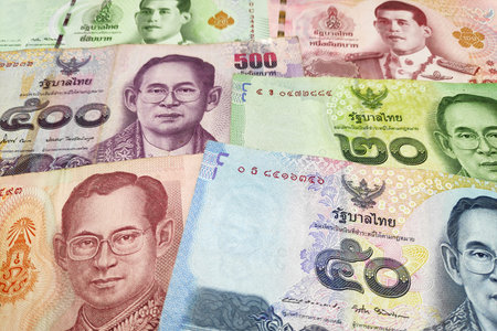 Stack of Thai baht banknotes as background.