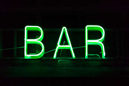 Close-up on a green neon light shaped into the word "Bar".の写真素材