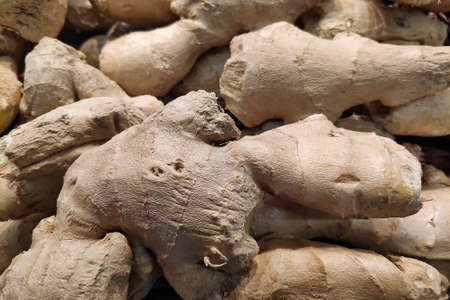 Full frame close-up on a stack of ginger on a market stall.の写真素材