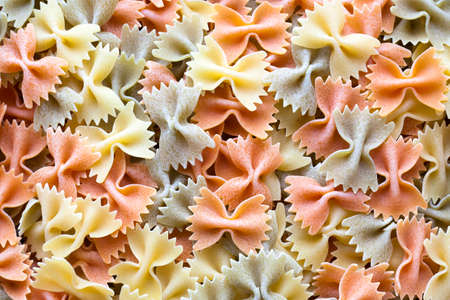 Close-up on a stack of colorful uncooked farfalle from Italy.の写真素材