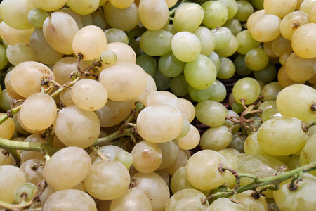 Close-up on a stack of white grapes for sale on a market stall.