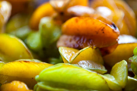Full frame close up on a stack of Carambolas on a market stall.の写真素材