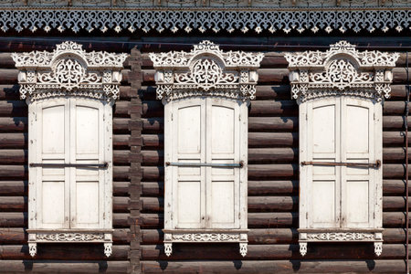 Details of the window-frames and shutters of a traditional Siberian wooden house near Holy Cathedral...