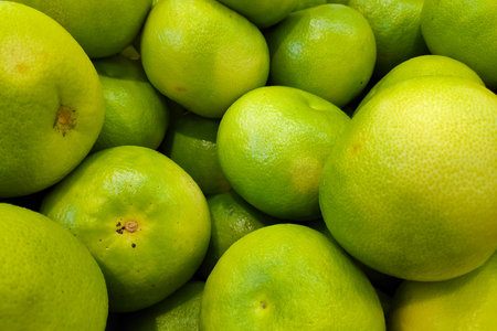 Close-up on a stack of Pomelos for sale on a market's stall.