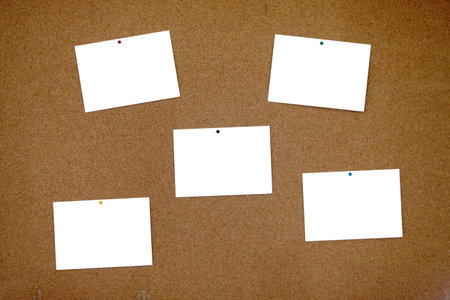 Full frame bulletin board made of cork with a five blank postcards pinned with thumbtacks to it. Each blank postcard can be filled with text or photo.の写真素材