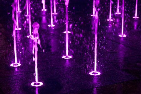 Close-up on purple lited splash pads in. the dark.の写真素材