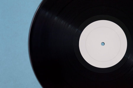 Close-up on a Vinyl record mockup with copy space on blue background.