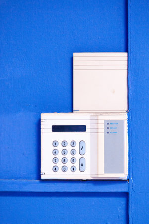 Alarm system fixed on a blue wall.の写真素材