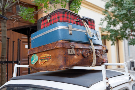 Old luggages atop of a white retro car.の写真素材