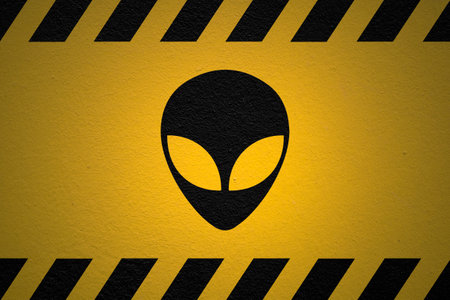 Black striped yellow background with an Alien warning sign and a light effect to dramatize the whole.の写真素材