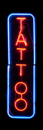 Close-up on a red neon light shaped into the word "Tattoo" in the middle of a blue neon rectangle.の写真素材