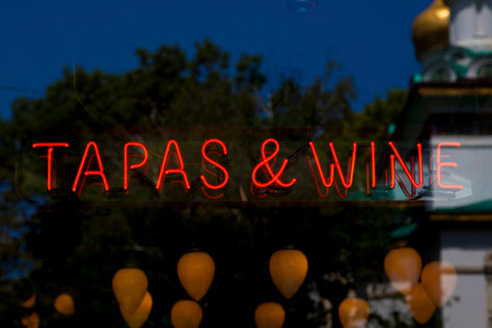 Close-up on a red neon light shaped into a the short phrase "Tapas & Wine".の写真素材