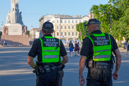 Riga, Latvia - June 14 2019: Two officers of the Riga Municipal Police (RÄ«gas paÅ¡valdÄ«bas policija) patrolling the square near Freedom Monument.のeditorial素材