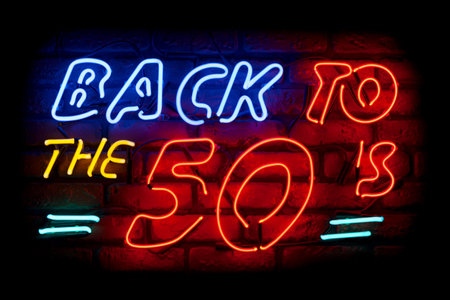 Neon light on a brick wall saying; Back to the 50's.の写真素材