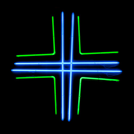 Close-up on a green neon light shaped in a cross used to show a pharmacy.の写真素材
