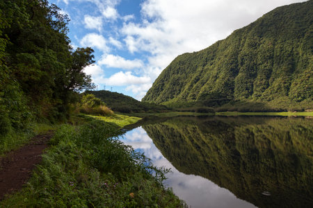 Footpath alongside Grand Ãtang (the biggest lake in Reunion Island) with the reflection of the rampart in the surface of the lake.の写真素材