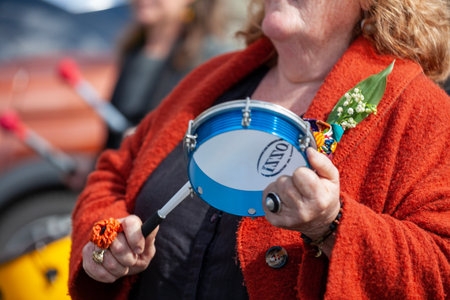 Carhaix, France - May 1 2023: Demonstration against pension reform with an elderly lady beating a tambourine in disapproval.のeditorial素材