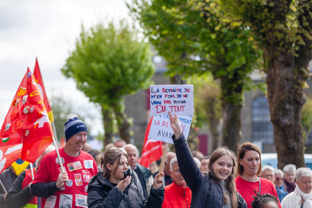 Carhaix, France - May 1 2023: Demonstration against pension reform with a teenage girl holding a sign saying in English: I don't care about retirement, I don't want to work at all.のeditorial素材