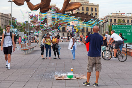 Barcelona, Spain - June 08 2018: Man making soap bubbles near the marina.のeditorial素材