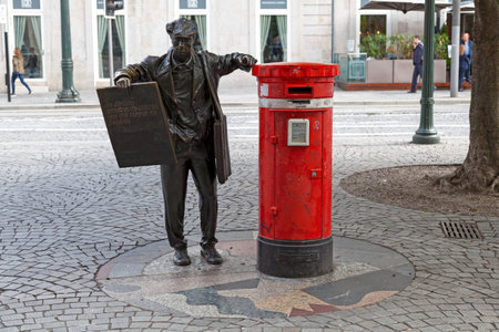 Porto, Portugal - June 03 2018: Traditional red Portuguese mail post on PraÃ§a da Liberdade, with a bronze statue of a newspaper's salesman called "O Ardina" created by Manuel Dias in 1990.のeditorial素材