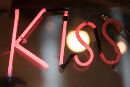 A pink neon light shaped into the word âKissâ.の写真素材