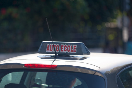 Car roof sign with written in it in French "Auto-Ãcole", meaning in English "Driving school".の写真素材