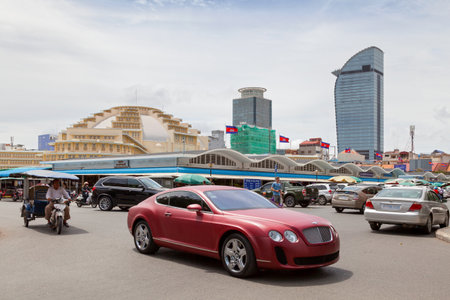 Phnom Penh, Cambodia - August 26 2018: The Central Market is a large market constructed in 1937 in the shape of a dome with four arms branching out into vast hallways with countless stalls of goods. Behind it, the tallest skyscraper in Phnom Penh is Vattaのeditorial素材